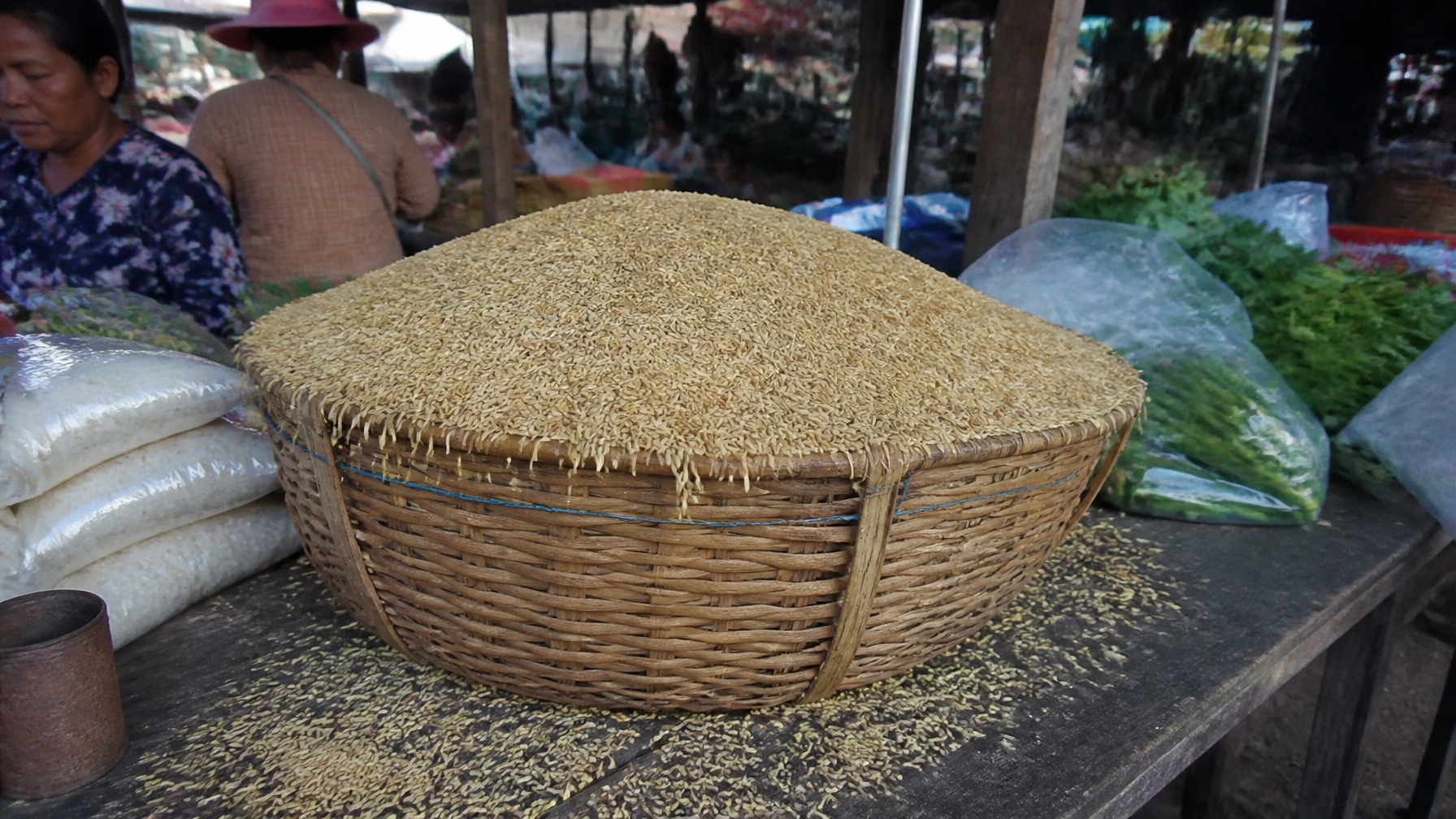 A basket in a Cambodian market overflowing with grain, illustrating the biblical promise of a pressed down and running over blessing.