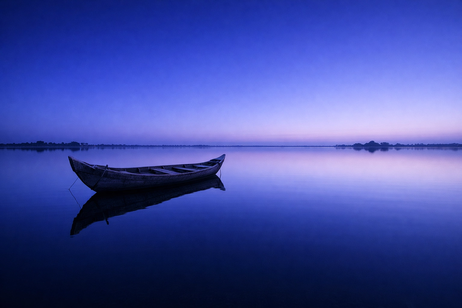 A calm scene of a wooden boat on a wide lake during sunrise. The sky is bright and clear.